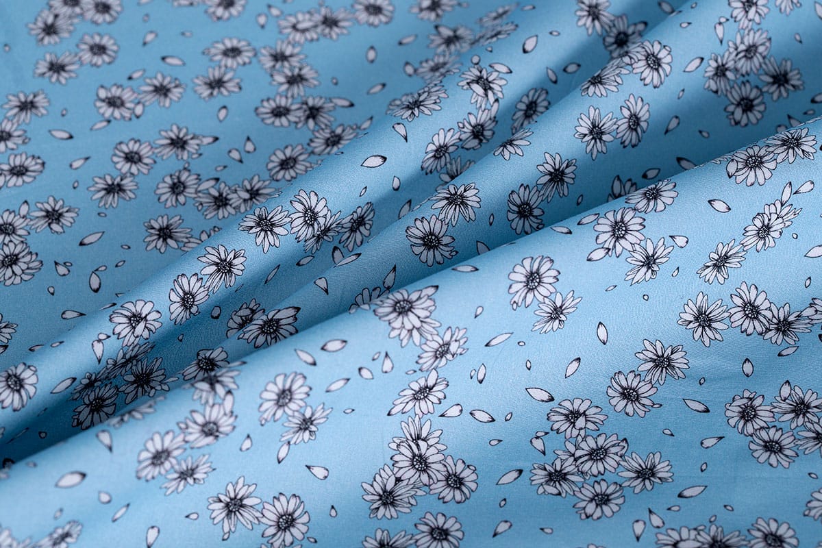 White floral cotton poplin fabric printed on a light blue background | new tess
