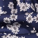 Tissu fleuri en popeline de coton imprimé sur un fond bleu | new tess