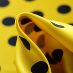 Silk satin fabric printed with a dark blue maxi polka dot motif on a yellow background | new tess