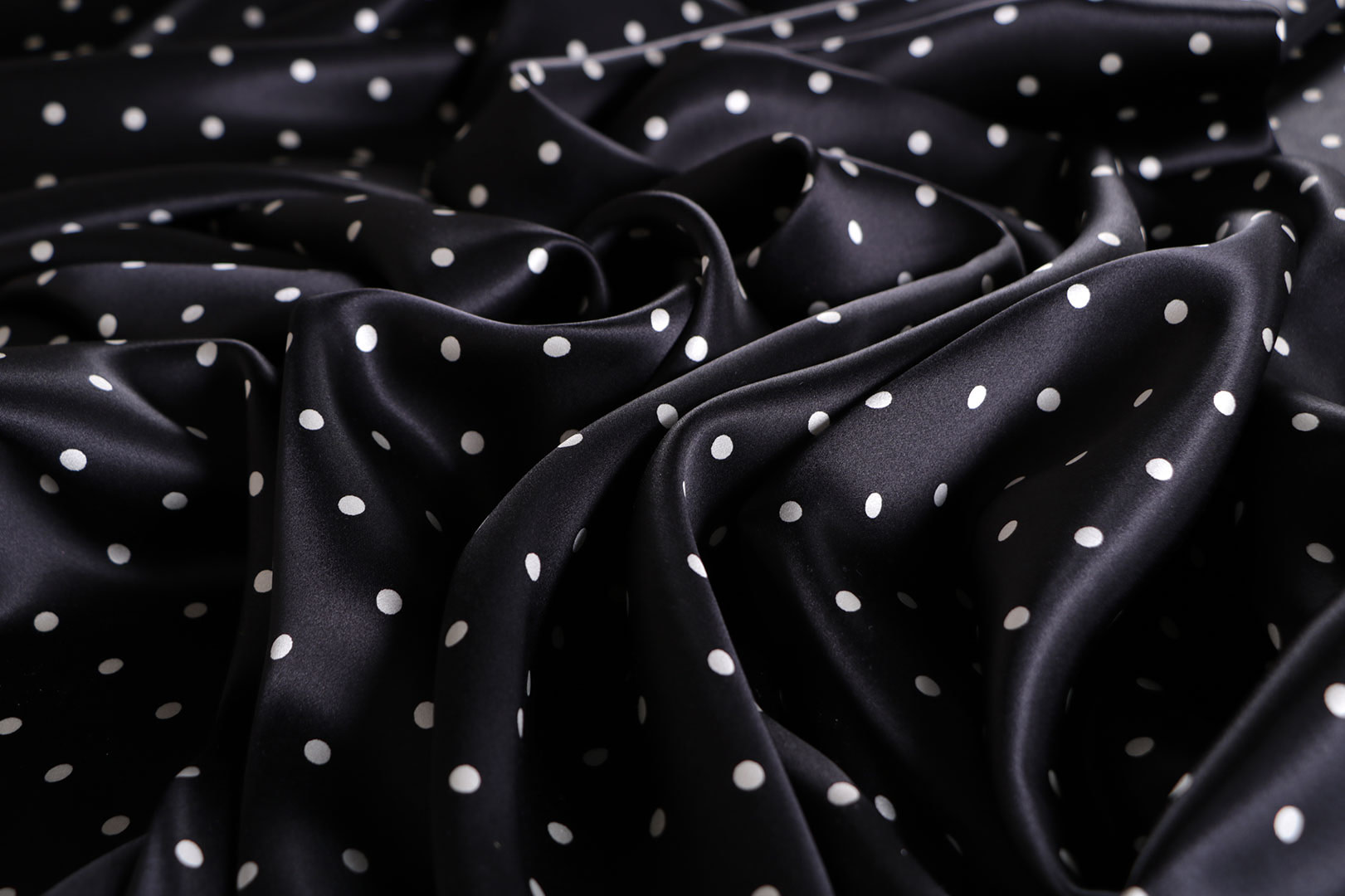Tessuto raso di seta con micro pois bianchi su fondo nero