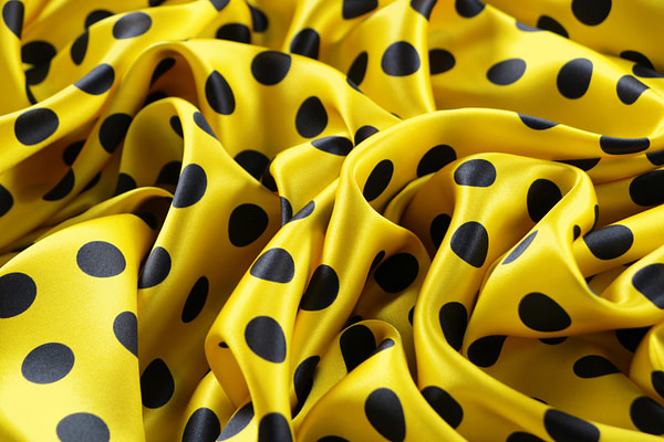 Silk satin fabric printed with a dark blue maxi polka dot motif on a yellow background | new tess
