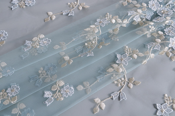 Light blue tulle fabric with floral mirror macrame embroidery
